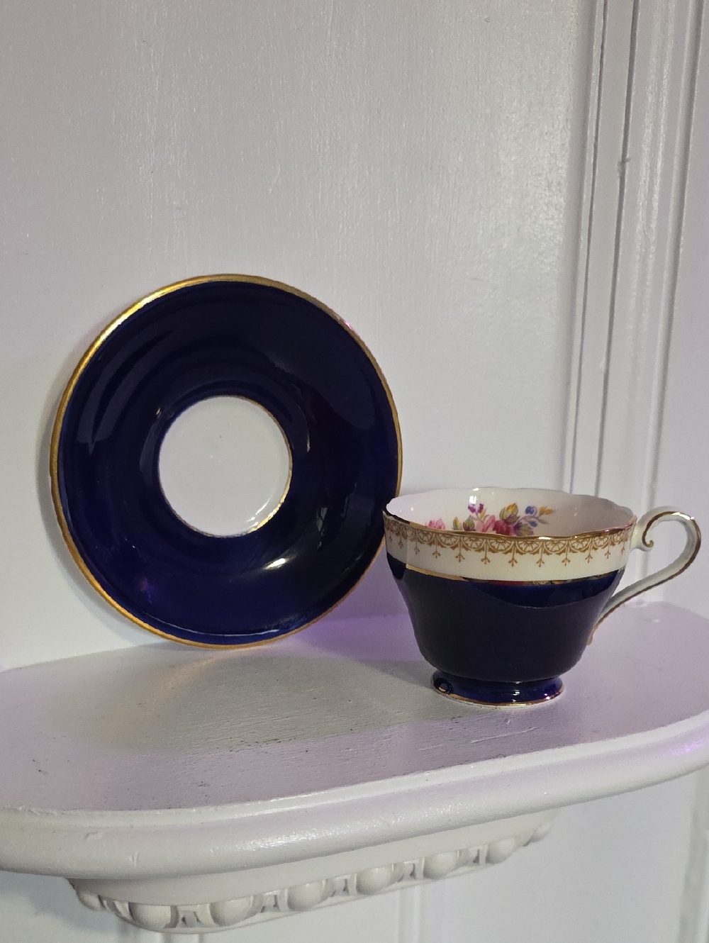 vintage Aynsley teacup and saucer set featuring a deep cobalt blue exterior